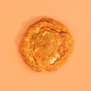 Pumpkin Spiced New York Cookie by Crumbs & Doilies with white chocolate and warm autumn spices on orange background
